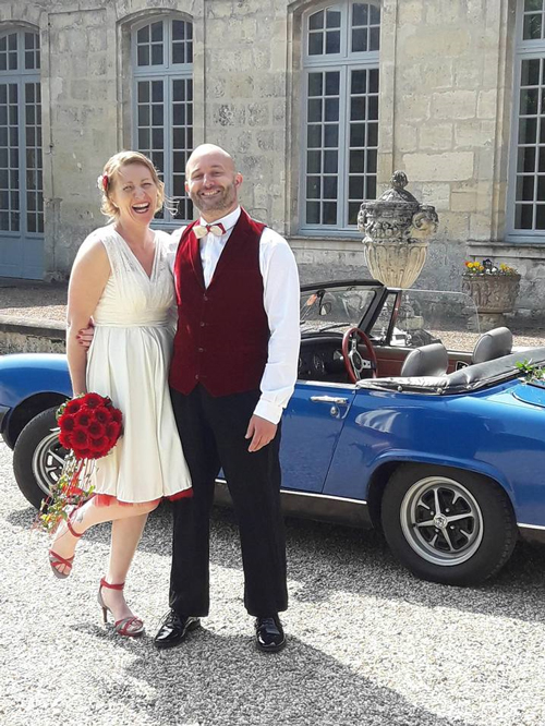 couple jeune marié devant voiture bleue décoré par fleurine